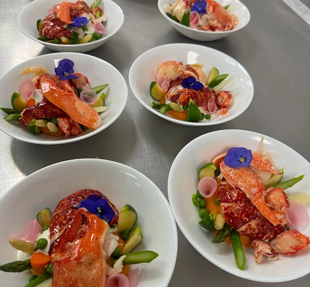 Serveuse en chemise noire et nœud papillon blanc, présentant des canapés à Suresnes près de Nanterre en Hauts-de-Seine 92