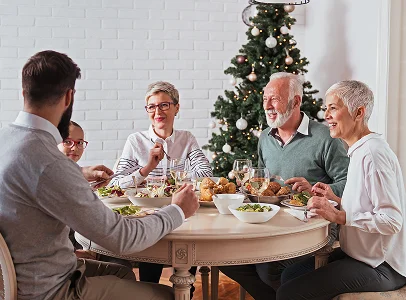 Famille de cinq générations partageant un repas de Noël joyeux autour d'une table festive à Suresnes près de Nanterre dans les Hauts-de-Seine 92