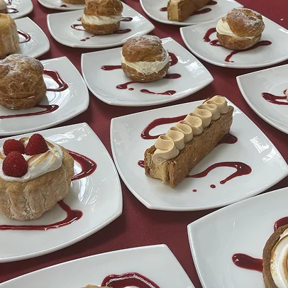 Assortiment de desserts individuels sur des assiettes blanches avec de la sauce aux fruits rouges à Suresnes près de Nanterre dans les Hauts-de-Seine 92