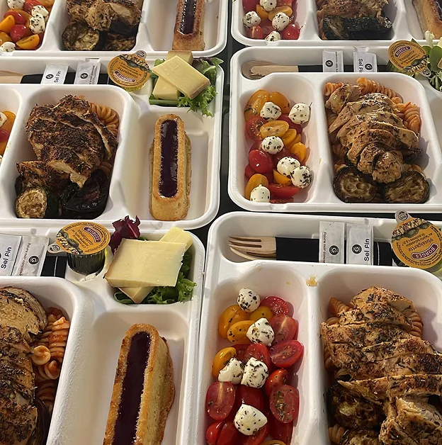 Plusieurs plateaux-repas avec poulet, pâtes, légumes grillés, salade caprese et desserts à Suresnes près de Nanterre dans les Hauts-de-Seine 92